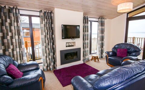 Loch Leven Lodge: Mobilia, Divano, Televisione, Comfort, Cornice, Viola, Finestra, Soggiorno, Legna, Pavimento