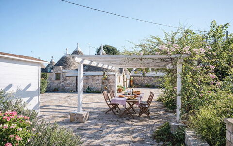 Trulli al Verde Viburno: Flagstone, Vaso Di Fiori, Giardino, Shade, Struttura Esterna, Pianta Della Casa, Landscaping, Cortile, Pergola, Cobblestone